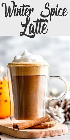 a cup of coffee with whipped cream on top and cinnamon sticks in the foreground