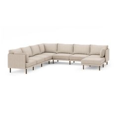 a large sectional couch with wooden legs