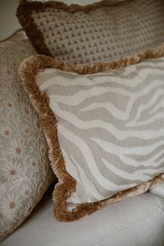 two pillows sitting on top of a couch next to each other