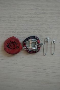 two red and black objects sitting on top of a wooden table next to each other