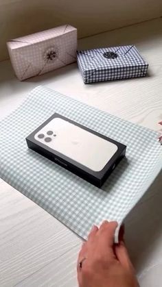 a person is opening an iphone box on a bed