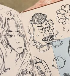 an open book with drawings of people and flowers on the pages, including a drawing of a man