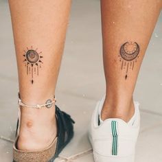 a woman's legs with tattoos on them and one has a sun and moon