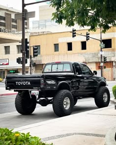 a black pickup truck driving down the street