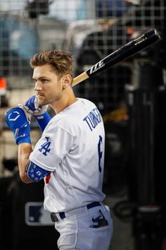 a man holding a baseball bat on top of a field