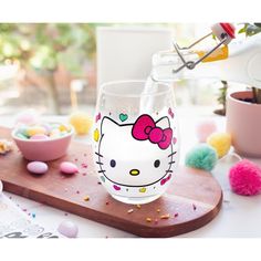 a hello kitty glass is being filled with candy