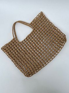 a brown woven bag sitting on top of a white table