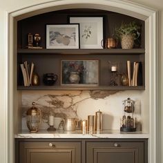 a kitchen with marble counter tops and gold accents on the cabinets in front of it