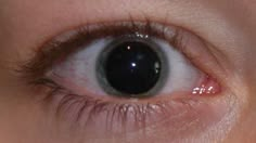 a close up of a person's eye with the iris partially closed and visible