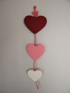 two hearts hanging from a string on a wall