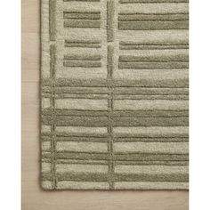 an area rug with squares and lines on the bottom, in light green color scheme