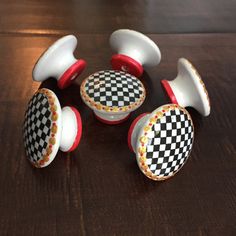 four ceramic knobs with checkerboard design on them sitting on a table next to each other