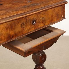 an old wooden table with drawers on it