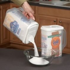 a person pouring milk into a bowl on top of a counter