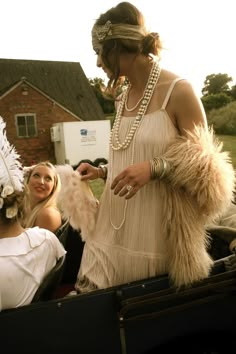 a woman in a feathered dress standing next to other women