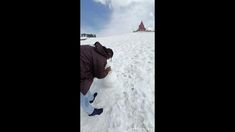 a man is standing in the snow with a plastic bag on his hand and looking at something