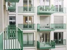 an apartment building with balconies and green railings