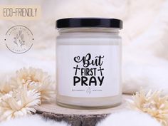 a candle with the words but first and pray on it