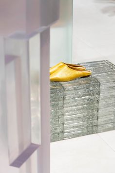 a yellow shoe sitting on top of a stack of glass blocks