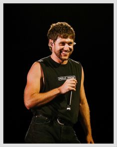 a man in black shirt holding a microphone