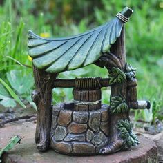 a small statue of a house with a roof made out of wood and leaves on it