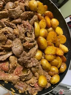 some meat and potatoes are cooking in a skillet