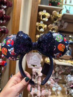 someone is holding up a mickey mouse ears headband with sequins on it