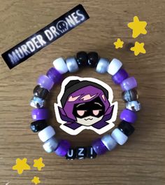 a purple and white beaded bracelet with a sticker on it