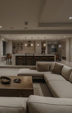 a living room filled with furniture and a bar in the back drop off wall behind it