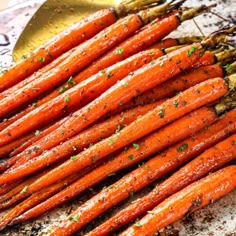 a bunch of carrots that are sitting on a plate with some seasoning next to them