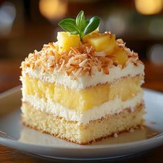 a piece of cake with pineapple and coconut toppings on top is sitting on a white plate