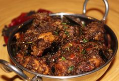 a pan filled with meat and vegetables on top of a table