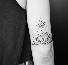 a woman's arm with a lotus tattoo on it