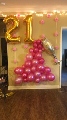 balloons are arranged in the shape of a christmas tree with pink and gold decorations on it