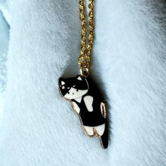 Add some whimsy to your jewelry collection with this charming Tuxedo Cat Necklace Pendant. This black & white gold tone necklace features a cute cat pendant with a lobster closure that is perfect for any cat lover. The pendant is adjustable and can be worn with any outfit, making it the perfect gift for any occasion. The necklace is made of an unknown material and is designed in a gold tone, giving it a luxurious look. The necklace is a great accessory for any outfit and can be worn for any occasion. The tuxedo cat design is perfect for cat lovers and the necklace can be given as a gift or stocking stuffer. The necklace is part of the Jewelry & Watches category and is specifically categorized under Fashion Jewelry, Necklaces & Pendants. Get this adorable Tuxedo Cat Necklace Pendant today a Cat Necklace, Black White Gold, Outfit Making, Gold Tone Necklace