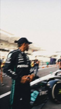 a man standing next to a race car on a track