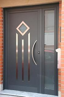 the front door to a brick building with two glass doors and an ornamental design on it