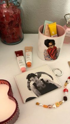 various items are displayed on a table with a heart shaped container in the middle and an image of a woman's face next to it