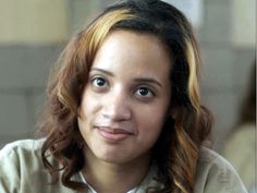 a woman with long hair is smiling at the camera