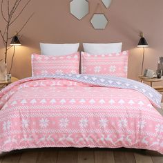 a bed with pink and white bedspread in a bedroom next to two lamps