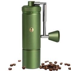 a green coffee grinder surrounded by coffee beans