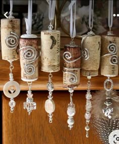 several wine corks are hanging from the ceiling with beads and feathers attached to them