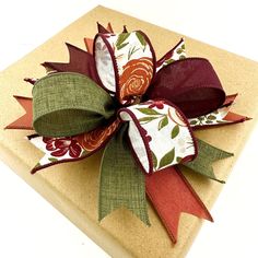 a gift wrapped in brown paper with a red and green bow