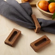 some wood pieces sitting on top of a table next to oranges and a cloth