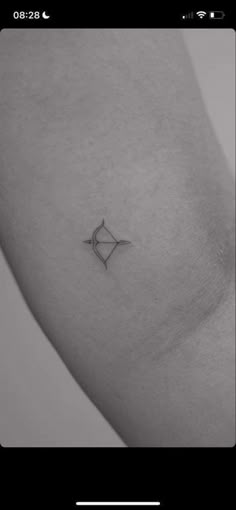 a black and white photo of a woman's arm with an arrow tattoo on it