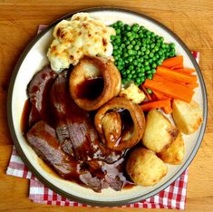 roast beef with potatoes, peas and carrots on a plate