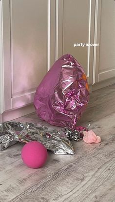 a pink ball and some foil on the floor