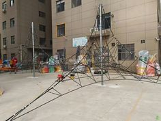 an outdoor playground with lots of equipment in front of a building