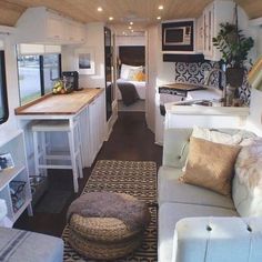 the interior of a mobile home with couches, tables and kitchen area in it