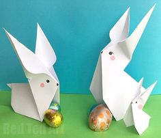 two paper rabbits are standing next to each other